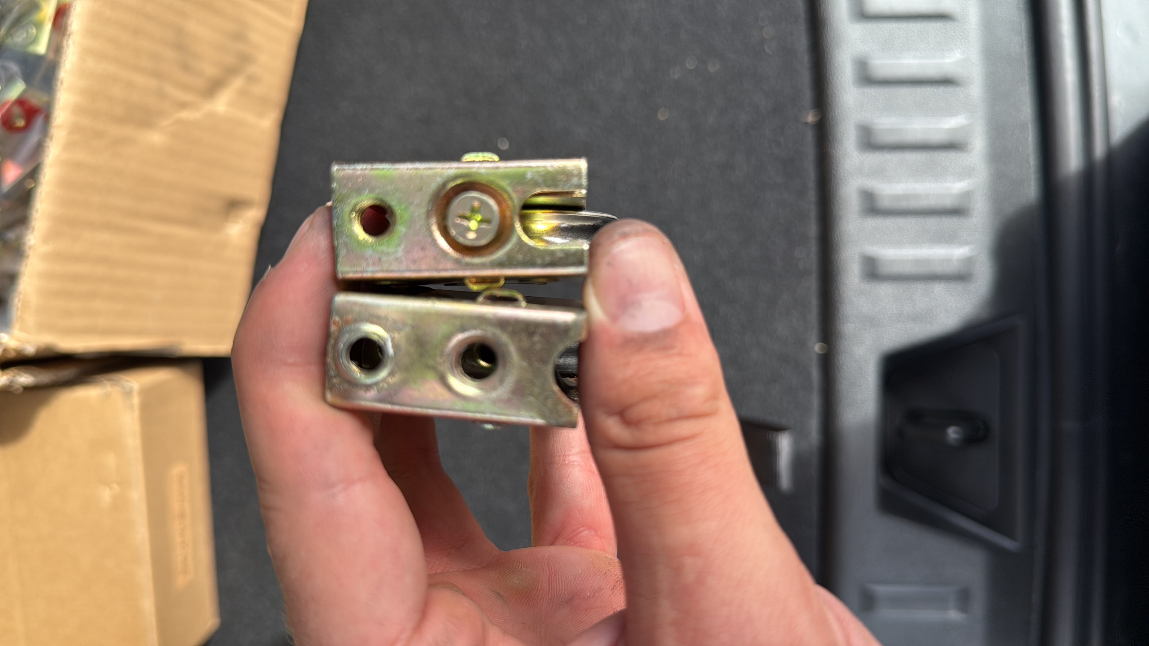 Close-up of sliding-door roller hardware held above a tool case